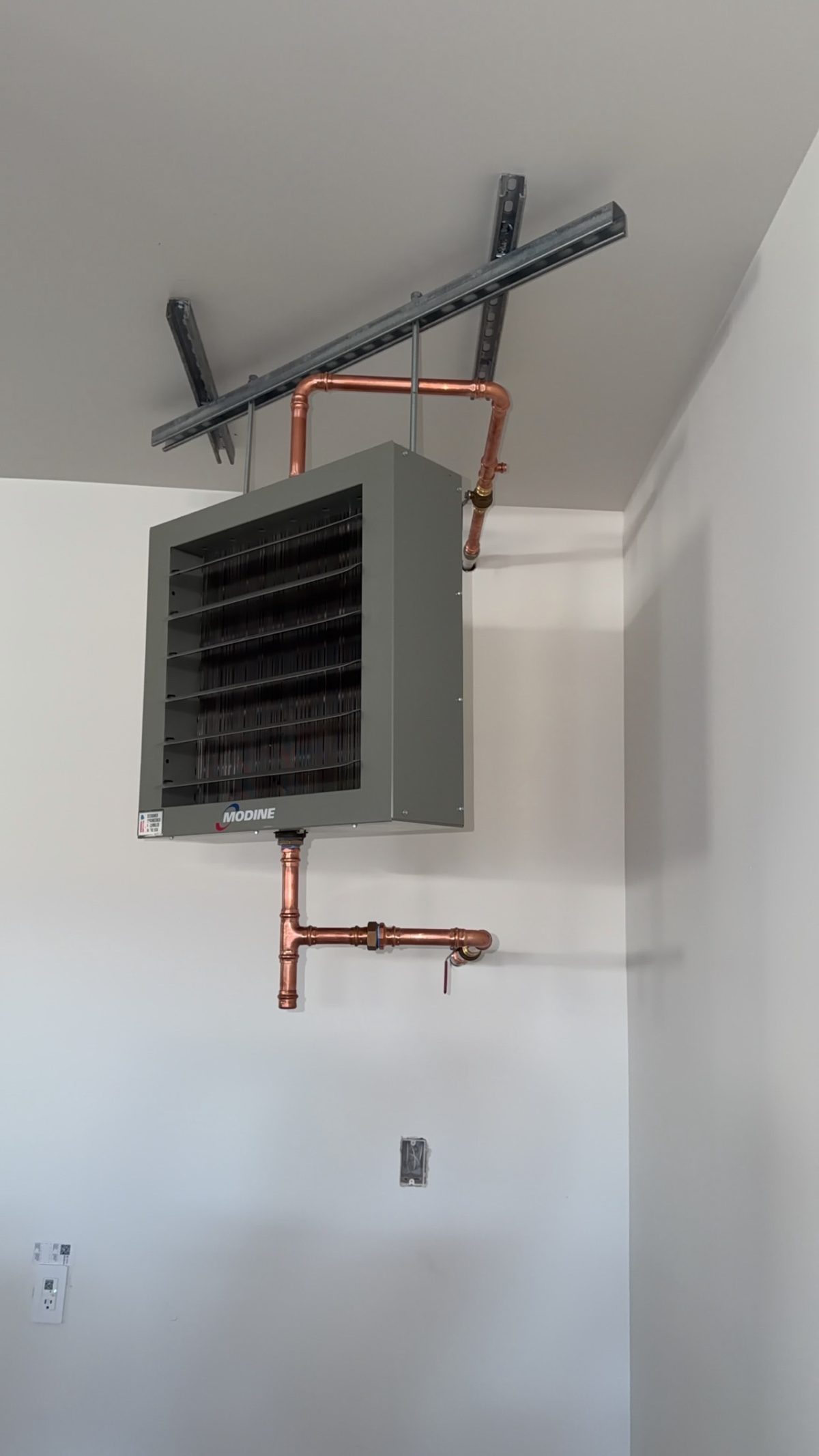 Modine hydronic unit heater with copper piping mounted on unistrut in shop