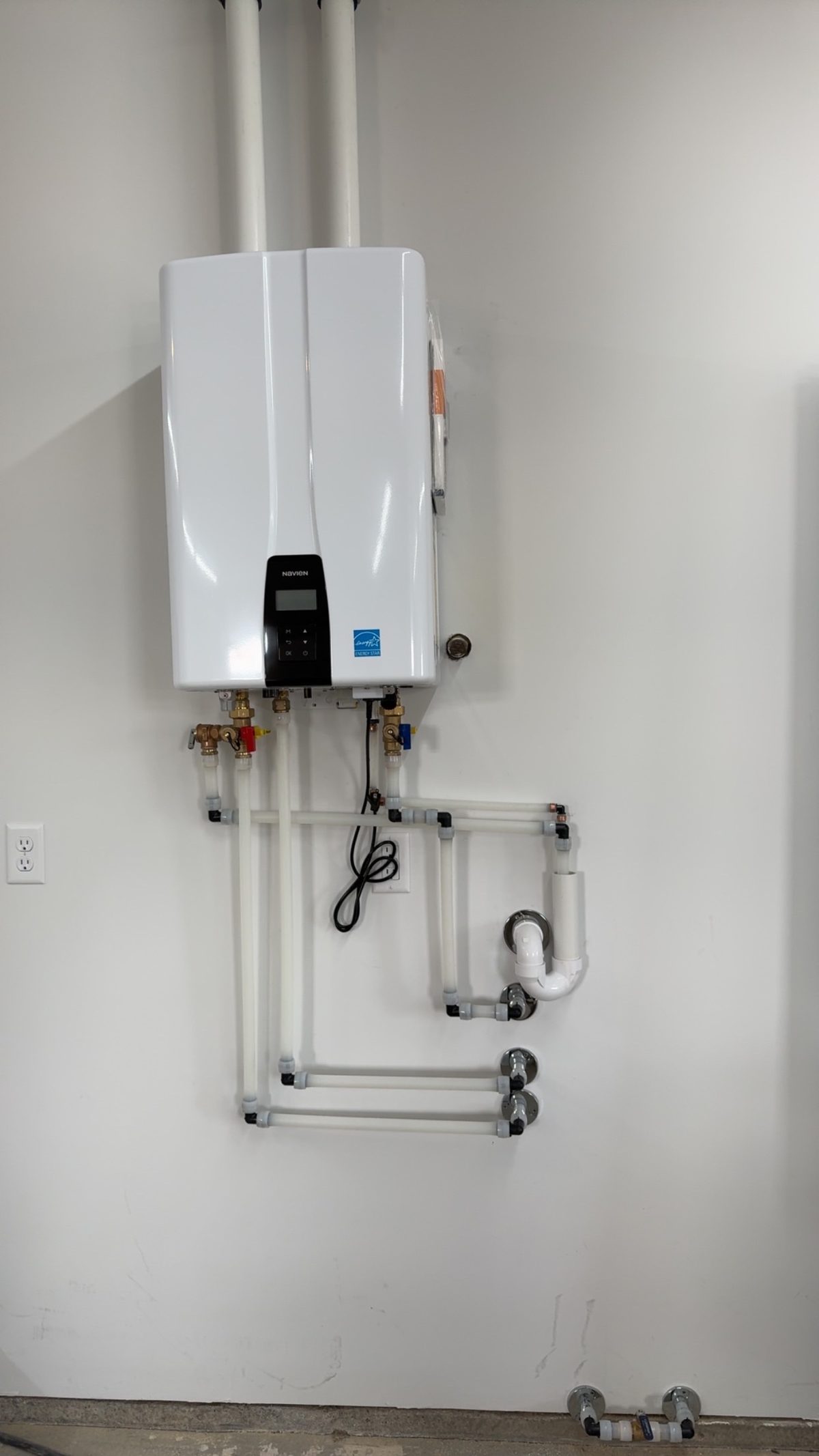 Navien tankless water heater with PVC piping installed by Wrangler Plumbing in Cody WY