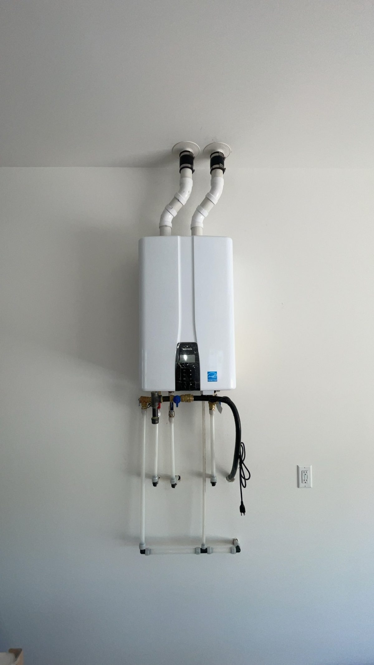 Clean Navien tankless water heater wall mount with dual PVC exhaust venting