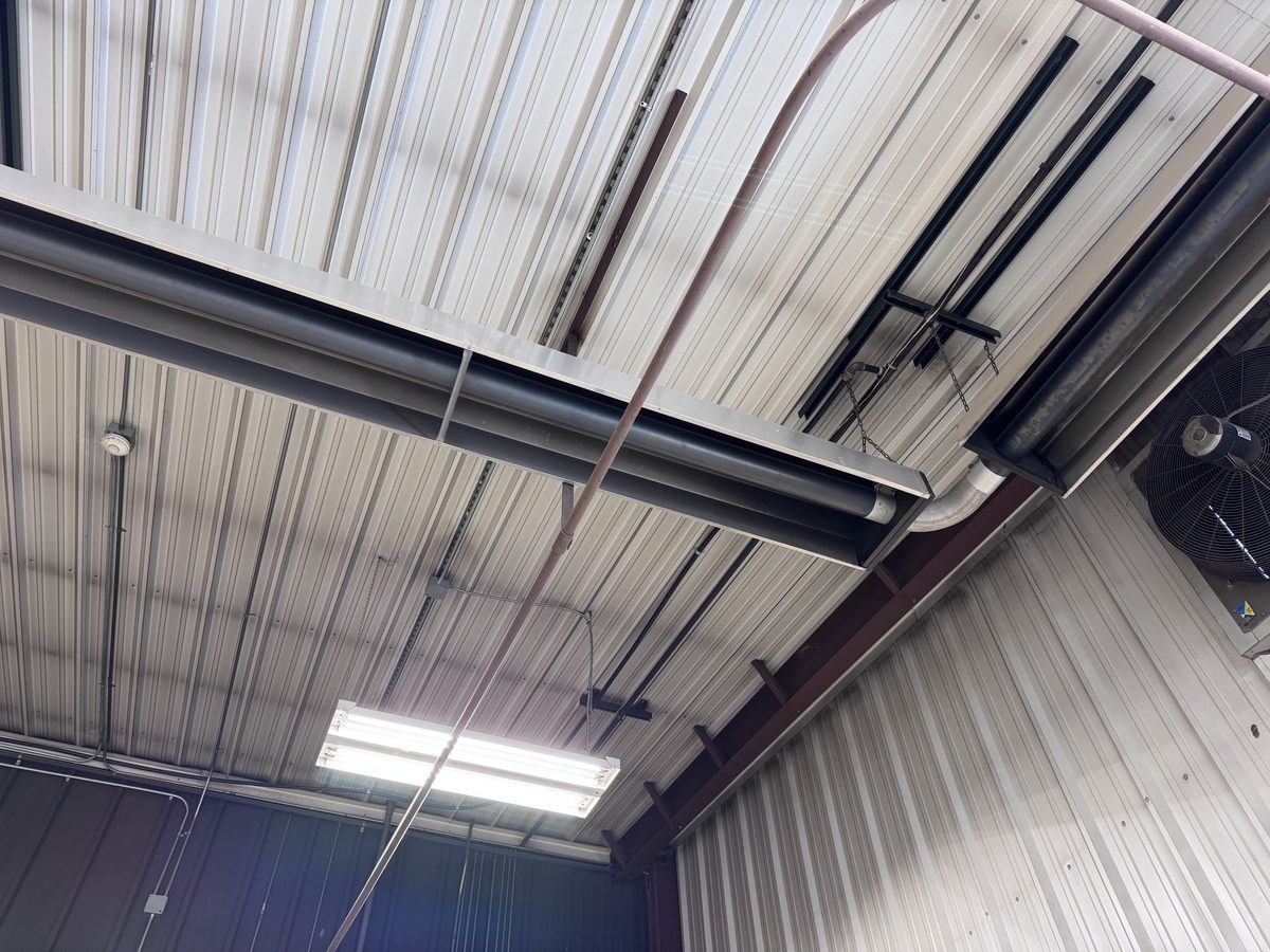 Overhead ductwork with circulation fan in shop